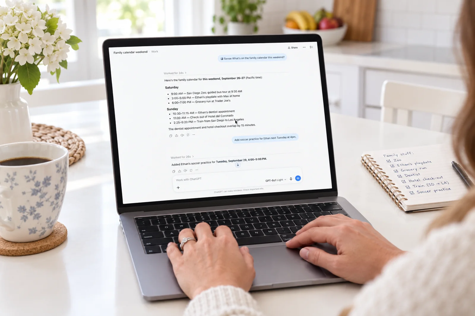 A laptop on a white kitchen table showing a ChatGPT conversation in which Sense lists the family's weekend and adds soccer practice for Ethan, with a school permission slip beside it